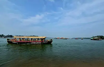 a boat in the water with people on it at Thiruthi Homestay in Vallikunnu