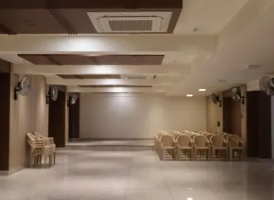 an empty room with a row of chairs and a stage at Hotel Vintage Classic in Coimbatore