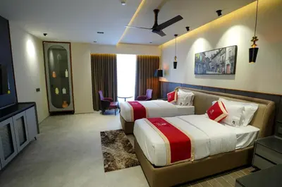 a hotel room with two beds and a television at Doro Royal Suite in Mannārakkāt