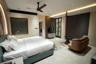 a bedroom with a large white bed and a chair at Doro Royal Suite in Mannārakkāt