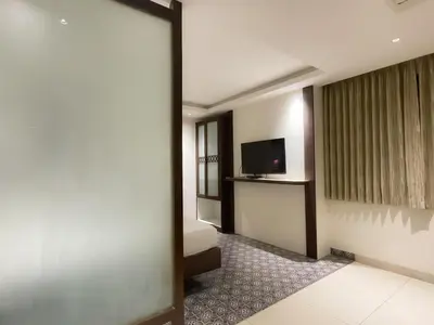 a hotel room with a bed and a television at SV Grand in Mettuppālaiyam