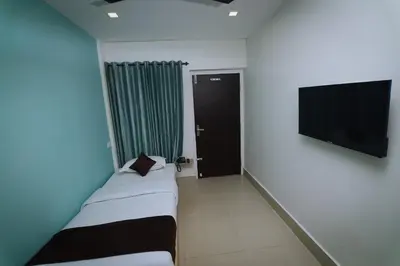 a room with two beds and a flat screen tv at Hotel Eastern in Sultan Bathery