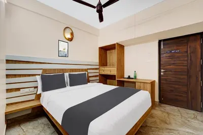 a bedroom with a large bed and a wooden cabinet at Super Hotel O Vilankurichi in Coimbatore