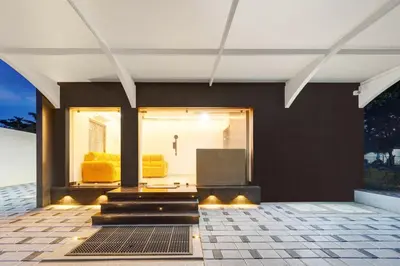 a house with black walls and yellow furniture at Super Hotel O Vilankurichi in Coimbatore