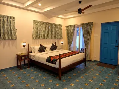 a bedroom with a bed and a ceiling fan at Ibex Resorts, Coimbatore Kakarla in Alāndurai