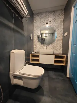 a bathroom with a white toilet and a mirror at Ibex Resorts, Coimbatore Kakarla in Alāndurai