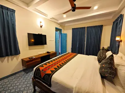 a bedroom with a bed and a flat screen tv at Ibex Resorts, Coimbatore Kakarla in Alāndurai