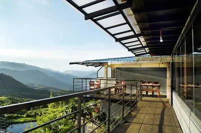 a balcony with a view of the mountains at Ibex Resorts, Valparai Tale Rock in Vālpārai