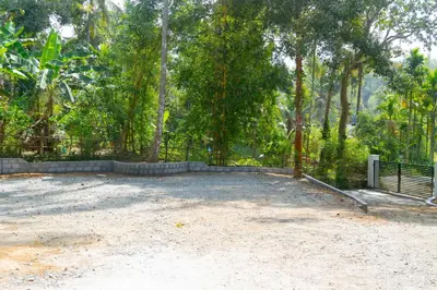 a parking lot with a fence and some trees at Pomma Holidays and Resorts in Muthanga