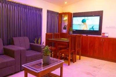 a living room with a couch and a table and a tv at Pomma Holidays and Resorts in Muthanga