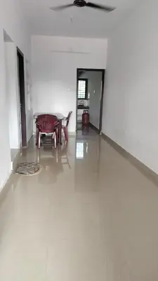 a living room with a table and a room with white walls at Aswathy Bhavan Near Star auditorium vadakkenchery in Palakkad