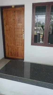 a wooden door and a window in a building at Aswathy Bhavan Near Star auditorium vadakkenchery in Palakkad