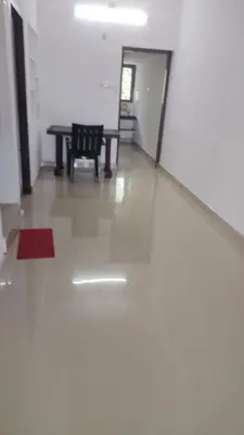a hallway with a table and a chair in a room at Aswathy Bhavan Near Star auditorium vadakkenchery in Palakkad
