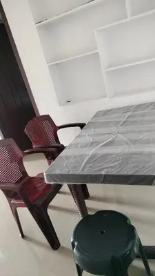 a table and two chairs with a plastic sheet on it at Aswathy Bhavan Near Star auditorium vadakkenchery in Palakkad