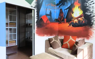 a living room with a fire mural on the wall at Gypsy habitat Backpackers Space in Wodapatti