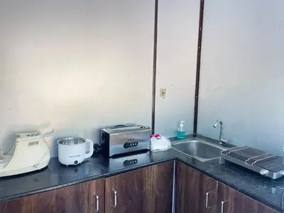 a kitchen counter with a toaster and a sink at Gypsy habitat Backpackers Space in Wodapatti