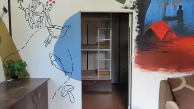 a room with a painting on the wall and a living room at Gypsy habitat Backpackers Space in Wodapatti