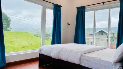 a bedroom with blue curtains and a large window at Away From Home - 6 - Home Stay Ooty, Entire 3BHK Villa in Ooty