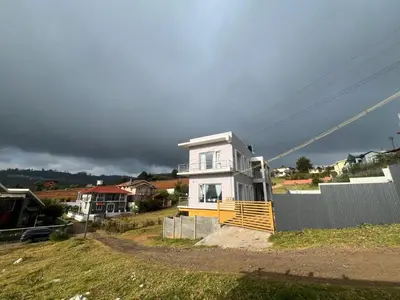 a white house on a hill with a fence at Away From Home - 6 - Home Stay Ooty, Entire 3BHK Villa in Ooty