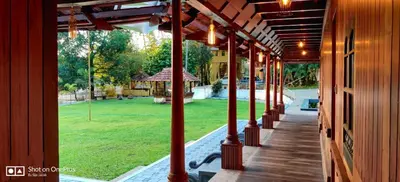 a porch of a house with a view of a yard at Sparrow Vale Resort in Kotamangalam