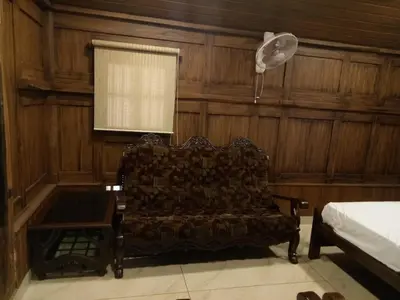 a room with a couch and a window and a bed at Sparrow Vale Resort in Kotamangalam