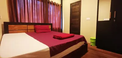 a bedroom with a bed with red pillows on it at Ginberry Holidays in Wayanad