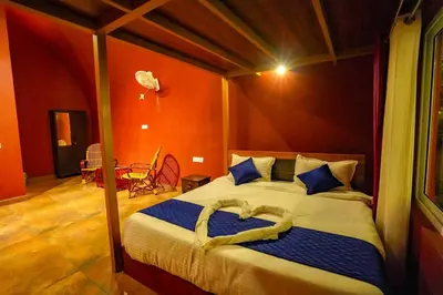 a bedroom with a large bed with blue pillows at Ginberry Holidays in Wayanad