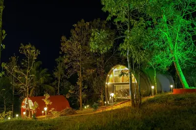 a house lit up at night with green lights at Ginberry Holidays in Wayanad