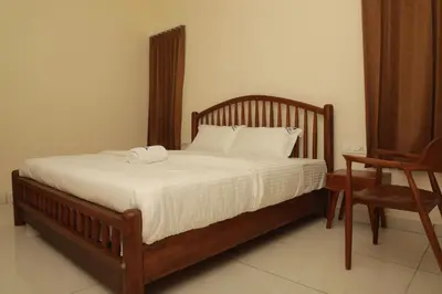 a bed with two towels on it in a bedroom at Nilgiri Woodlands Luxury Service Apartments in Mysore