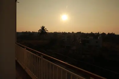 a view of the sunset from a balcony at Nilgiri Woodlands Luxury Service Apartments in Mysore