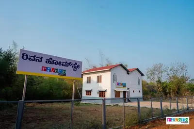 a sign in front of a white house at Rivana Homestay in Kushālnagar