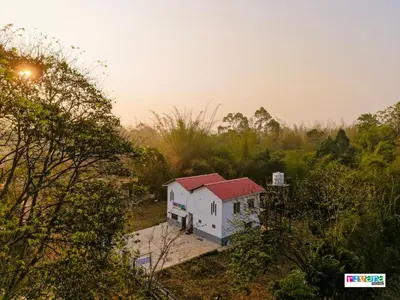 an aerial view of a white house with a red roof at Rivana Homestay in Kushālnagar