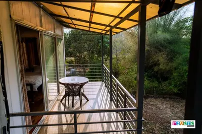 a screened porch with a table on the balcony at Rivana Homestay in Kushālnagar