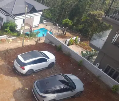 two cars parked in a yard next to a house at mountain lake view private pool villa -Wayanad in Meppādi