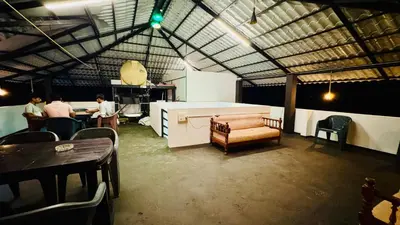 a group of people sitting at a table in a room at mountain lake view private pool villa -Wayanad in Meppādi