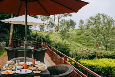 a table with plates of food and an umbrella at Green Nest Resort Ooty in Kotagiri
