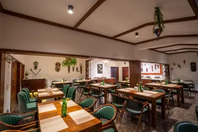 a restaurant with wooden tables and green chairs at Green Nest Resort Ooty in Kotagiri