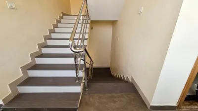 a staircase in a house with a metal handrail at Rodas Serviced Apartment in Coimbatore