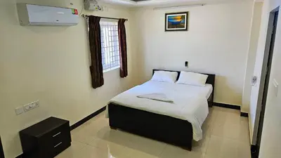 a bedroom with a bed in a room with a window at Rodas Serviced Apartment in Coimbatore