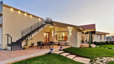 a house with a patio with a table and chairs at SaffronStays Coonoor Canvas in Coonoor