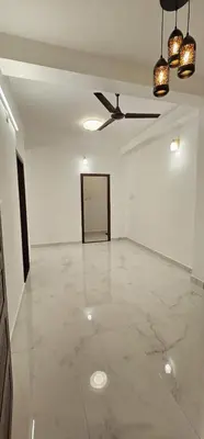 a large white room with a ceiling fan and a door at Munnar House in Munnar