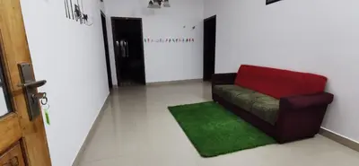a living room with a red couch and a green rug at Munnar House in Munnar