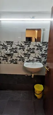 a bathroom with a sink and a mirror at Munnar House in Munnar