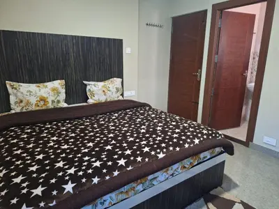 a bedroom with a large bed with stars on it at Golden Gate Luxury Villas by LexStays in Ooty
