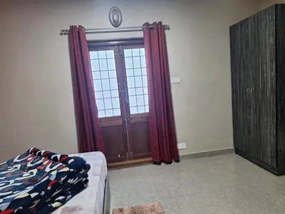 a room with a door and a window with red curtains at Golden Gate Luxury Villas by LexStays in Ooty