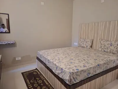 a bedroom with a bed with a wooden headboard at Golden Gate Luxury Villas by LexStays in Ooty