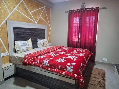 a bedroom with a bed with a red blanket at Golden Gate Luxury Villas by LexStays in Ooty