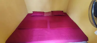 a bed with pink sheets and pillows in a room at Mount Camp in Marayoor