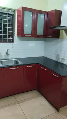 a kitchen with red cabinets and a sink at ZAREPHATH PG Home in Trichūr
