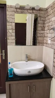 a bathroom sink with a mirror on a counter at ZAREPHATH PG Home in Trichūr